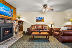 Box Canyon Lodge & Hot Springs large suite living room with fireplace, leather sofa and arm chair