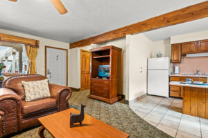 Box Canyon Lodge & Hot Springs large suit living room with leather arm chair and partial view of kitchen